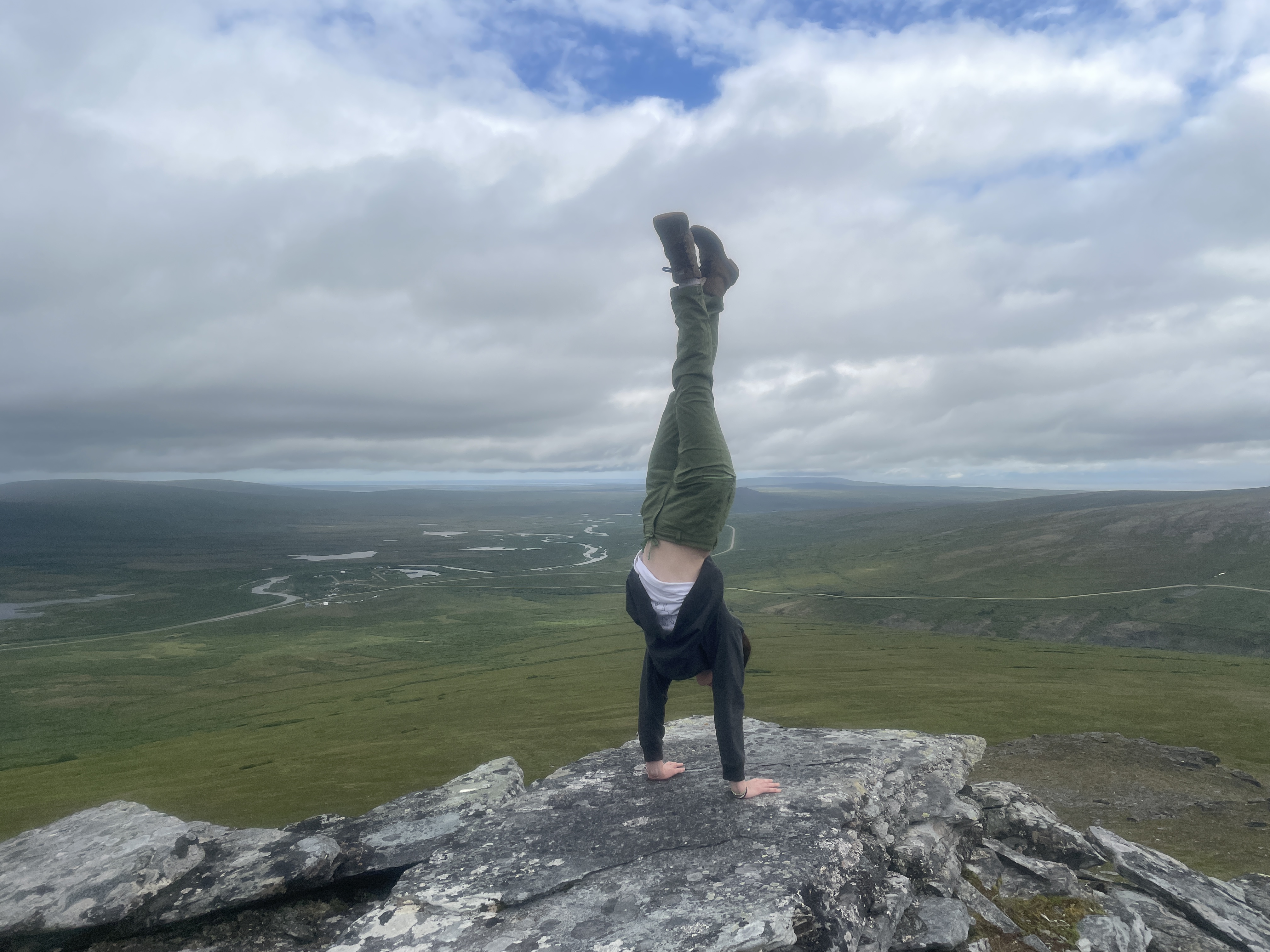 girl doing a handstand at the top of a mountain